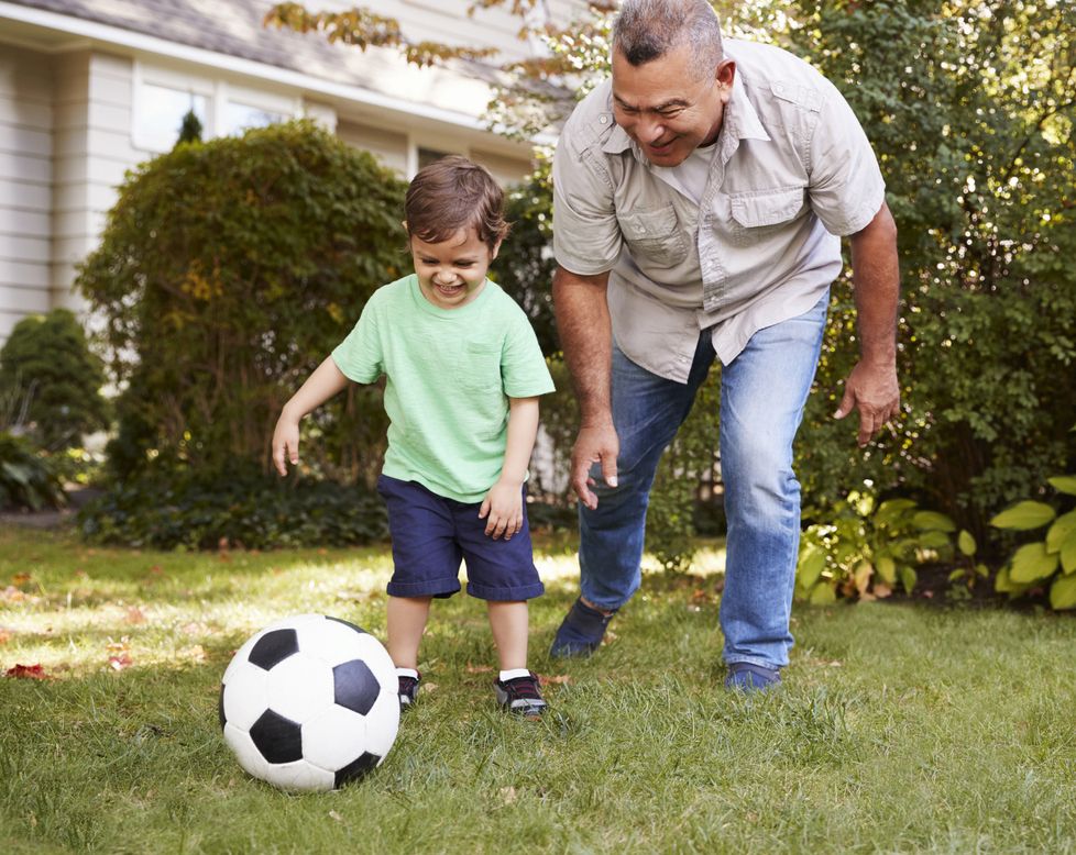 Grandfather playing soccer with grandson